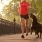 dog runs next to owner across a park bridge